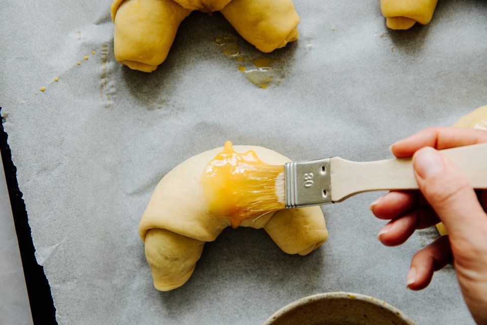 Gipfel mit Pinsel und Eigelb bestreichen