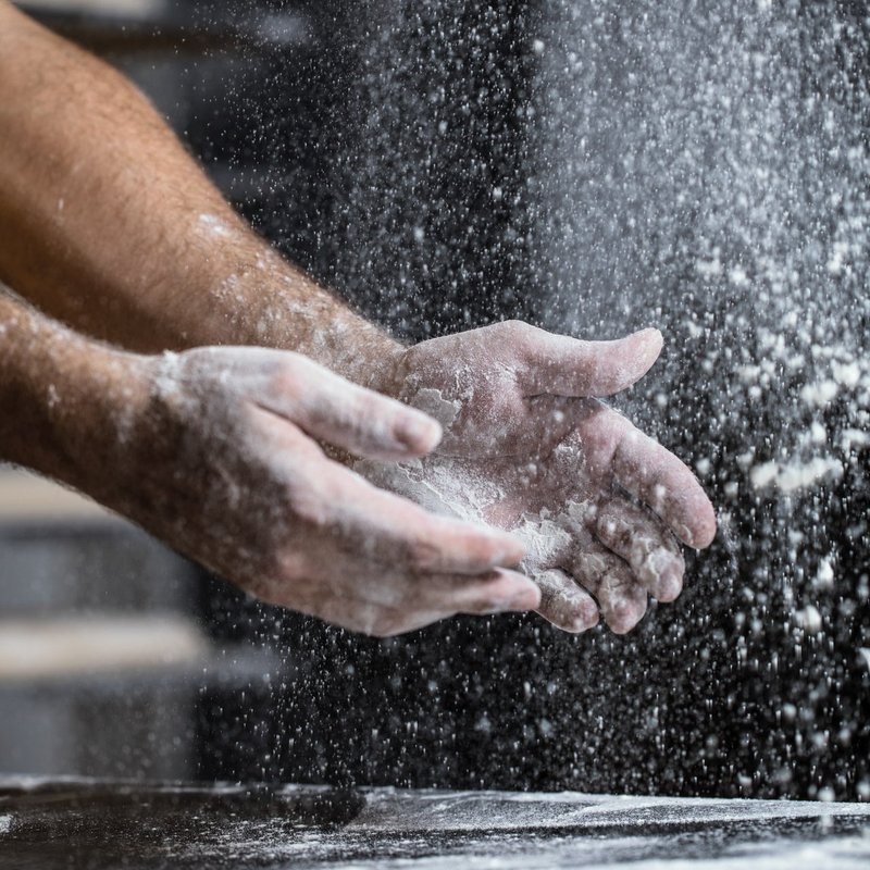 Hände werfen Mehl hoch